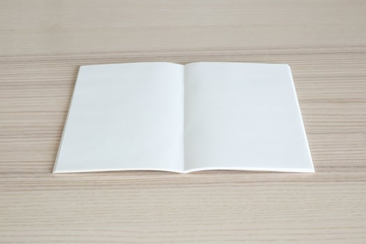 Mock up blank open paper book on wood table background photo