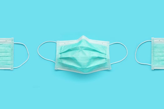 Surgical face mask on blue background protection against COVID-19 coronavirus. Healthcare and medical concept photo