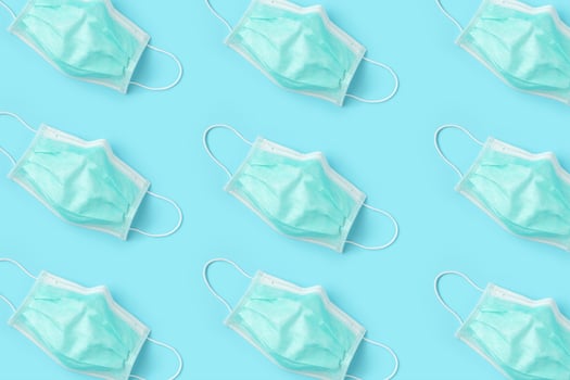 Surgical face mask on blue background protection against COVID-19 coronavirus. Healthcare and medical concept photo