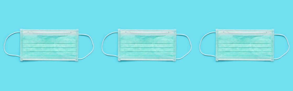 Surgical face mask on blue background protection against COVID-19 coronavirus. Healthcare and medical concept photo