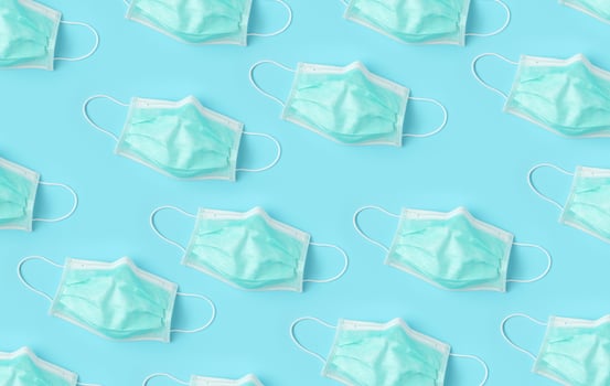 Surgical face mask on blue background protection against COVID-19 coronavirus. Healthcare and medical concept photo