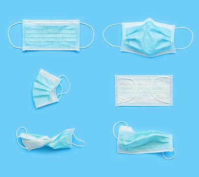 Surgical face mask on blue background protection against COVID-19 coronavirus. Healthcare and medical concept photo