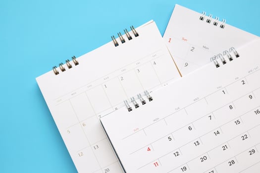 calendar page close up on blue background business planning appointment meeting concept photo