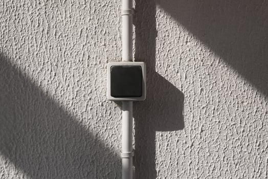 Simple electric switch on the white grungy wall, power toggle, flat plastic light on and off button, home electrical turn, house electricity shutdown press element. photo