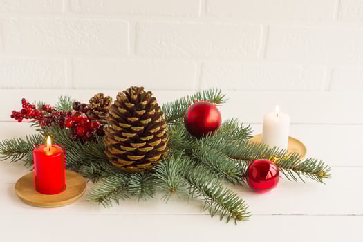 New Year's composition to decorate the festive house and table. spruce branches, a branch with berries, a candle, balls and a cone of cedar. photo
