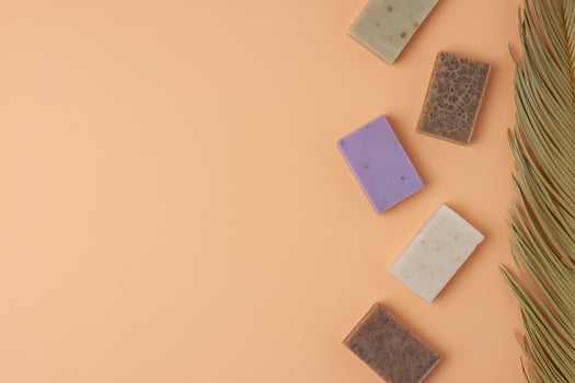 Soap and palm on beige background. Flat lay, copy space. photo