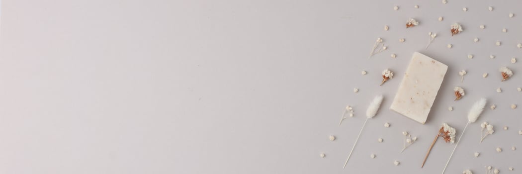Soap and flower on grey background. Flat lay, copy space. photo