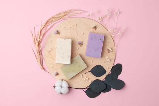 Soap with flowers on pink background. Flat lay, copy space. photo