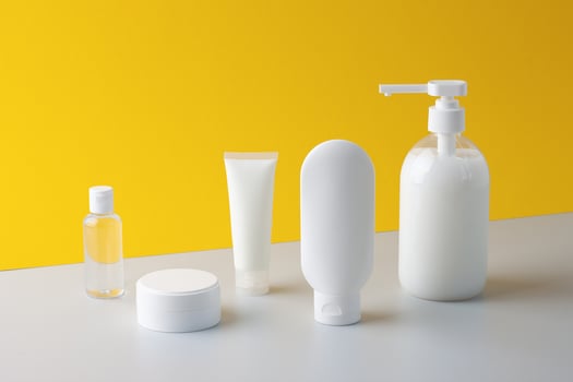 Cosmetic composition with skin care products on yellow background. Close up. photo
