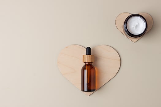 Cosmetic skin care products with a wooden heart on pastel beige background. Flat lay, copy space photo