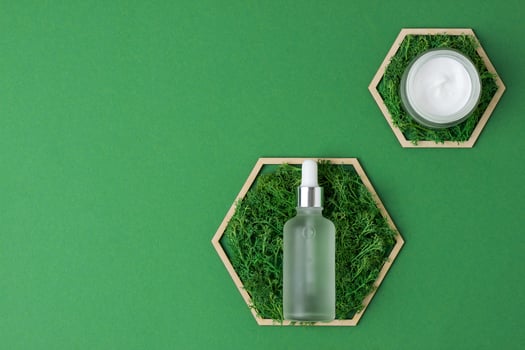 Cosmetic skin care products with a wooden hexagon and moss on green background. Flat lay, copy space photo