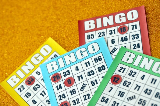 Many colorful bingo boards or playing cards for winning chips. Classic US or canadian five to five bingo cards on bright background photo
