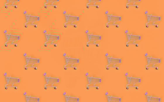 Shopping addiction, shopping lover or shopaholic concept. Many small empty shopping carts perform a pattern on a pastel colored paper background. Flat lay composition, top view photo