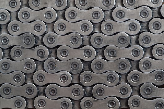 Dirty and oily chain from a mountain bike lying on a wooden table in a bicycle shop photo