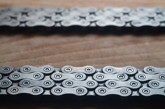 Dirty and oily chain from a mountain bike lying on a wooden table in a bicycle shop photo