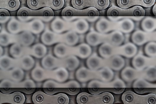 Dirty and oily chain from a mountain bike lying on a wooden table in a bicycle shop photo