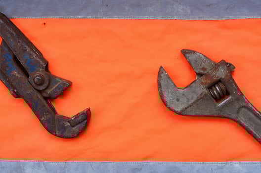 Adjustable and pipe wrenches against the background of an orange photo