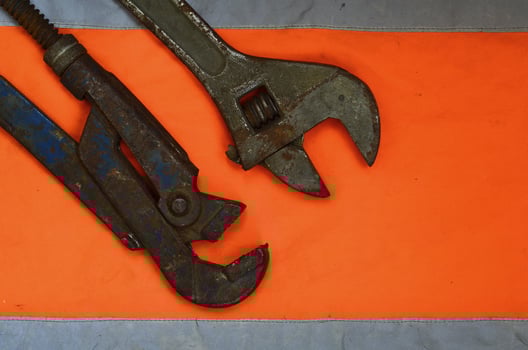 Adjustable and pipe wrenches against the background of an orange photo
