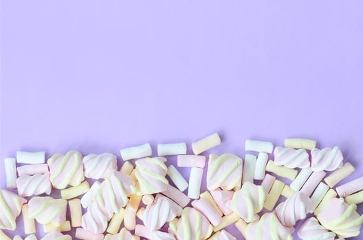 Colorful marshmallow laid out on violet paper background. pastel creative texture. minimal photo