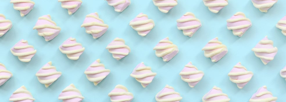 Colorful marshmallow laid out on blue paper background. pastel creative textured pattern. minimal photo