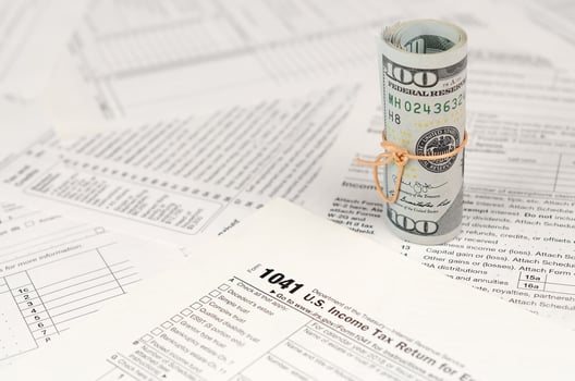 1041 U.S. Income tax return for Estates and Trusts form with roll of american dollar banknotes photo