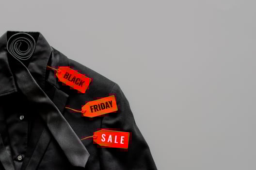 Flat lay of men black color shirt, suit, necktie and red price tags on gray background for Black Friday sale concept. photo