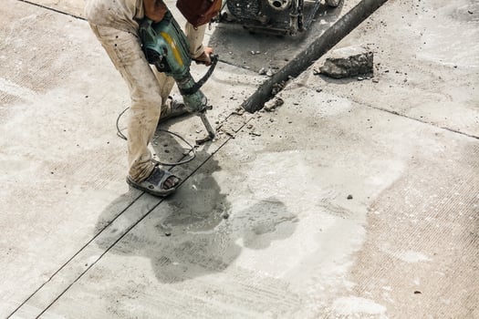 Construction worker using jackhammer drilling concrete surface photo