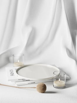 3d ceramic plate on magazines with dried plant and candle against white fabric background. 3d rendering of realistic presentation for product advertising. 3d minimal illustration. photo