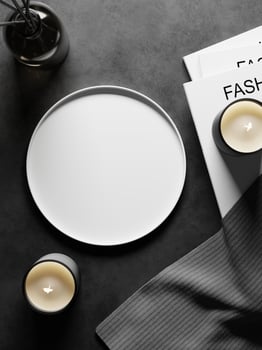 3d white ceramic plate on black concrete floor with magazines, fabric, candles and diffuser. 3d rendering of realistic presentation for product advertising. 3d minimal illustration. photo
