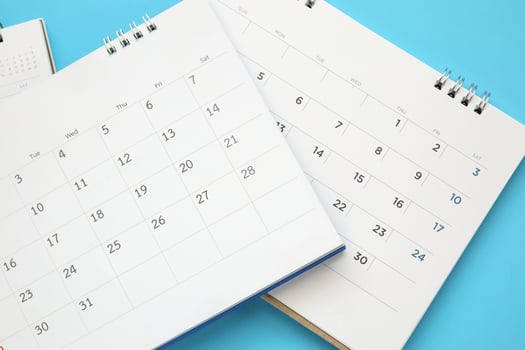 calendar page close up on blue background business planning appointment meeting concept photo