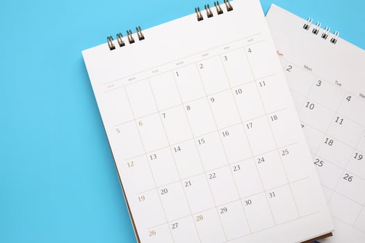 calendar page close up on blue background business planning appointment meeting concept photo