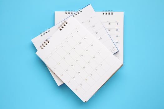 calendar page close up on blue background business planning appointment meeting concept photo