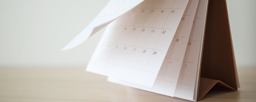 Calendar page flipping sheet on wood table background business schedule planning appointment meeting concept photo