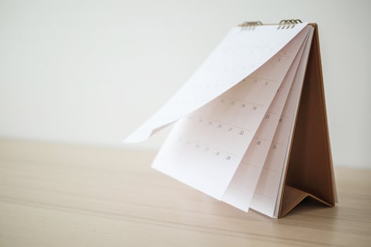 Calendar page flipping sheet on wood table background business schedule planning appointment meeting concept photo
