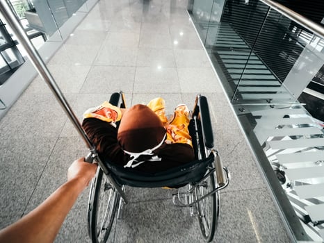 A personal point of view of me pushing a senior woman in a wheelchair at a private hospital in Kuala Lumpur, Malaysia photo