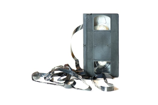 An old cassette with the tape coming out. photo