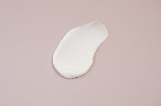 White cream texture on a pink background. photo