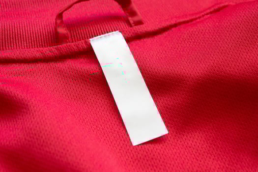 White blank clothes label on red jersey texture background photo