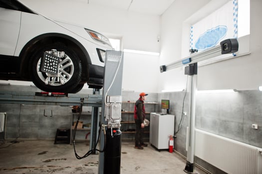American SUV car on stand for wheels alignment camber check in workshop of service station. photo