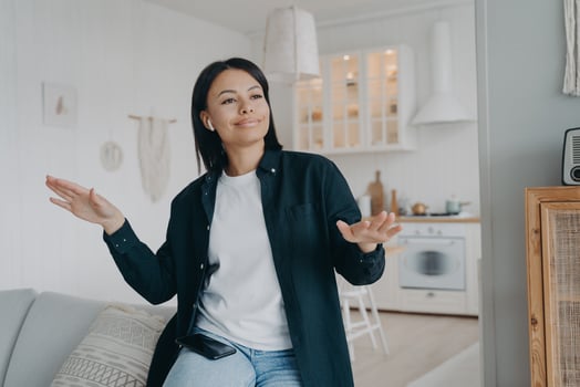 Energetic happy young woman wearing earphones listening to music, dancing, enjoying song at home photo