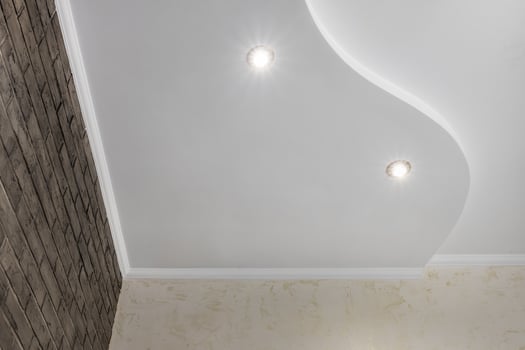 Detail of corner ceiling with intricate crown molding. Suspended ceiling and drywall construction in empty room in apartment or house. Stretch ceiling white and complex shape. photo