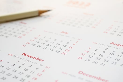 white pencil on calendar background business planning appointment meeting concept photo