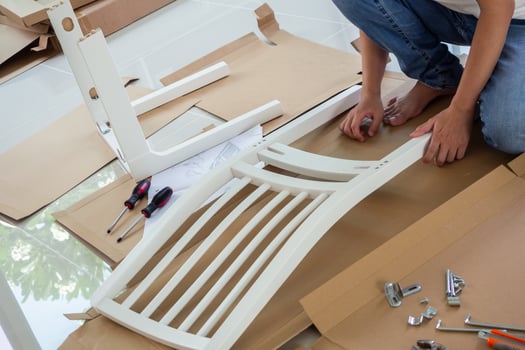 Man assembling white chair furniture at home photo