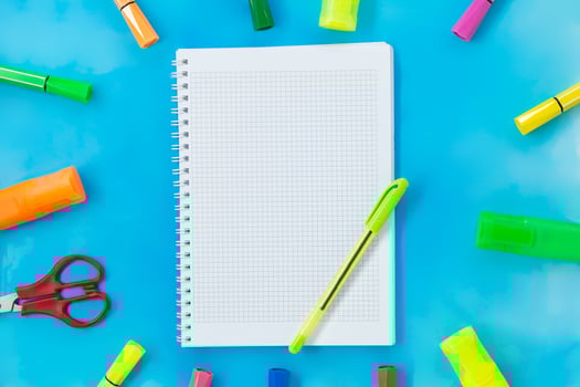 Felt tip pens, scissors and notepad for drawing or writing. Stationery on blue background. Concept back to school, education. Copy space photo