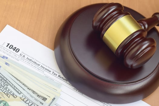 Justice mallet and 1040 IRS U.S. Individual income tax return form and hundred dollar bills photo