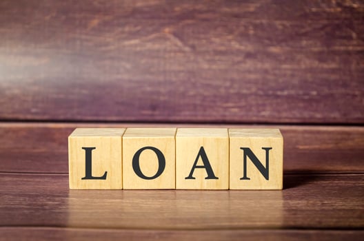 LOAN concept with wooden block on wooden table background. photo