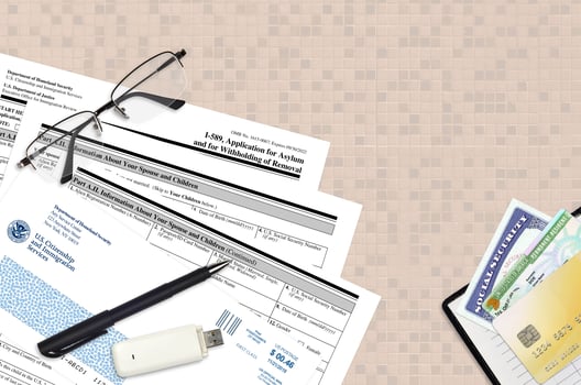 USCIS form I-589 Application of asylum and for withholding of removal lies on flat lay office table and ready to fill. U.S. Citizenship and Immigration services paperwork concept photo