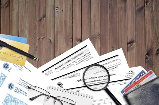 USCIS form I-765 Application for employment authorization lies on flat lay office table and ready to fill. U.S. Citizenship and Immigration services paperwork concept photo