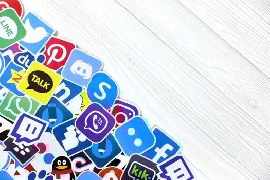 KHARKOV, UKRAINE - DECEMBER 26, 2020 Paper logos of most popular social networks and mobile messengers on wooden background. Facebook instagram youtube twitter tiktok twitch reddit etc. photo