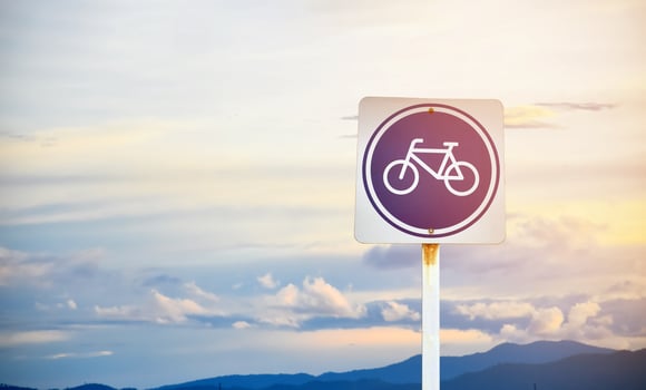Bike path traffic sign on metal pole, soft and selective focus, blur main road background. photo
